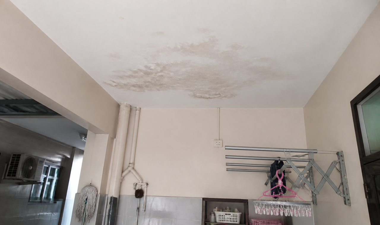 Siling bawah tangki air lembap dengan tompok air di rumah Malaysia.